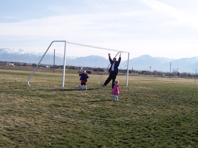 Emma, Sarah, and Dad playing soccer