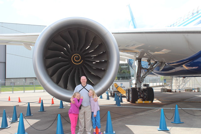 Sarah, Steve, and Emma in front of the engine of a 787