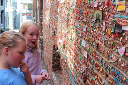 Sarah and Emma adding their offering to the gum wall in Seattle