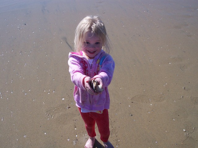 Sarah showing off her shell collection at Huntington Beach