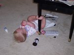 Emma with her legs hooked around the piano bench