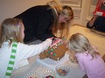 Jillian, Sarah, and Emma building a gingerbread house on Emma's 6th Birthday